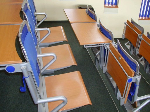 posluchárenské lavice se sklopnými stolky s čalouněnými opěráky na zádech z perforovaného plechu