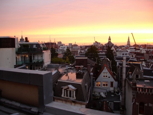 ranní pohled směrem k východu na střechy centra Amsterdamu, ze  západu hotel omývá kanál Sinegel